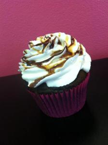 Chocolate cupcake with chocolate chips folded in, topped with a creamy vanilla buttercream and a chocolate and caramel drizzle.